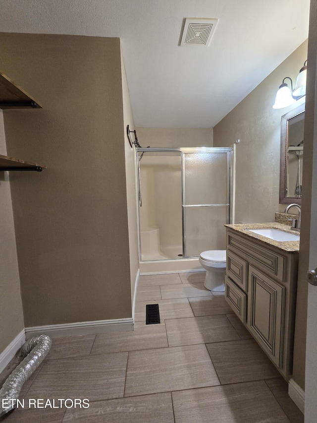 full bathroom featuring a stall shower, visible vents, vanity, and toilet