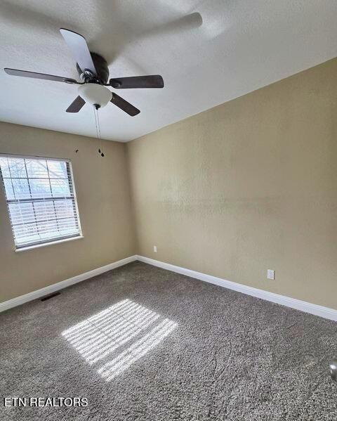 carpeted empty room with baseboards, visible vents, ceiling fan, and a textured ceiling