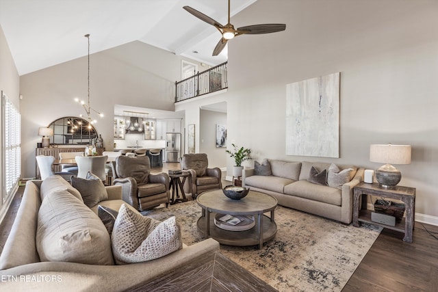 living room with high vaulted ceiling, dark hardwood / wood-style floors, and ceiling fan with notable chandelier