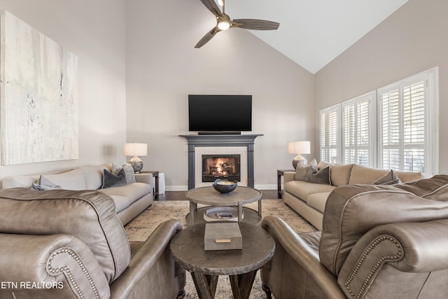 living room featuring ceiling fan, a fireplace, and high vaulted ceiling