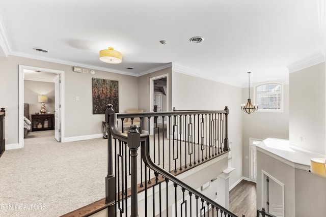 corridor featuring crown molding, carpet flooring, and a notable chandelier