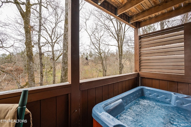 sunroom featuring wood ceiling, a hot tub, and beamed ceiling