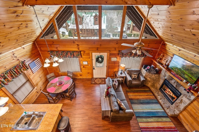 living room with hardwood / wood-style flooring, a fireplace, and wooden walls