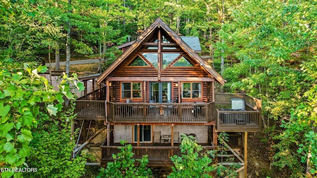 rear view of property featuring a wooden deck and log siding