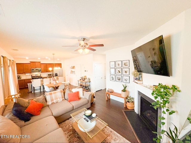 living room featuring dark wood-type flooring and ceiling fan