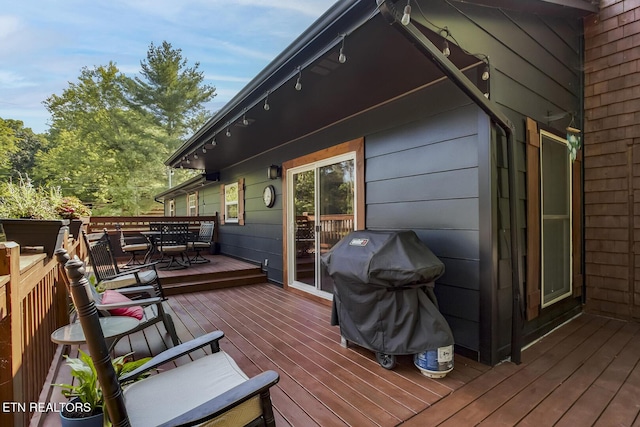 wooden deck featuring a grill