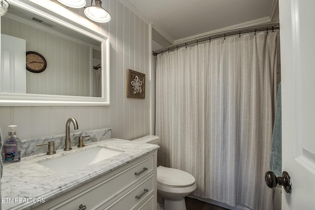 bathroom with crown molding, vanity, toilet, and curtained shower