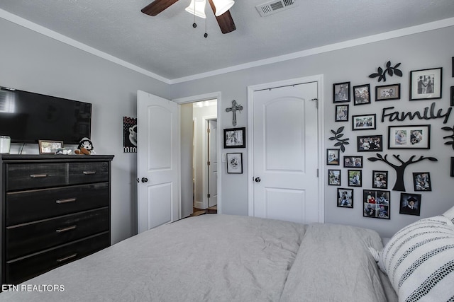 bedroom featuring ornamental molding, ceiling fan, and a textured ceiling