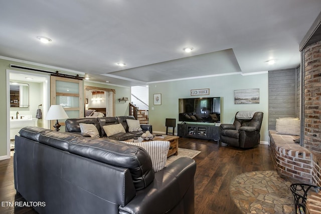 living room featuring ornamental molding, a barn door, and dark hardwood / wood-style flooring