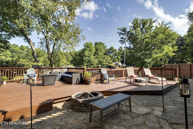 view of patio / terrace with a wooden deck and a fire pit