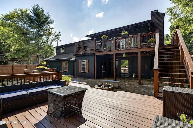 wooden terrace featuring an outdoor living space with a fire pit