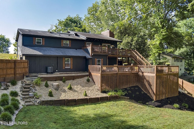 rear view of house with a deck, a lawn, and central air condition unit