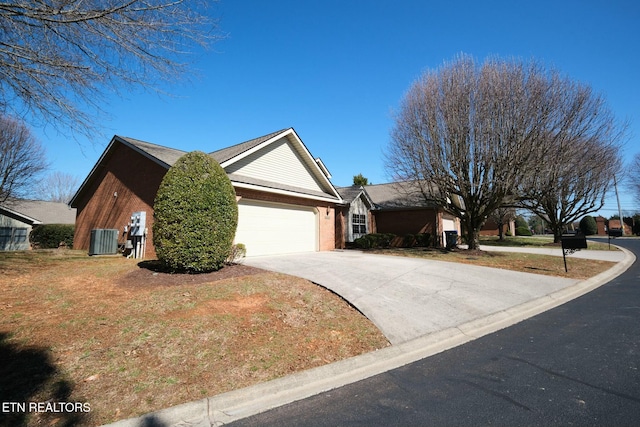 ranch-style house featuring a garage, concrete driveway, central AC, and brick siding