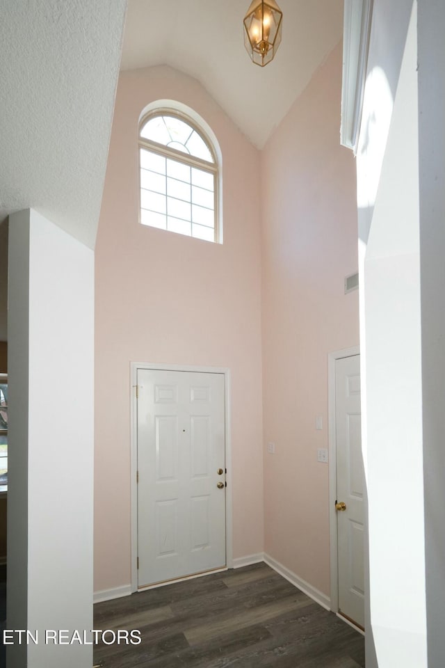 entrance foyer with baseboards, high vaulted ceiling, and dark wood-type flooring