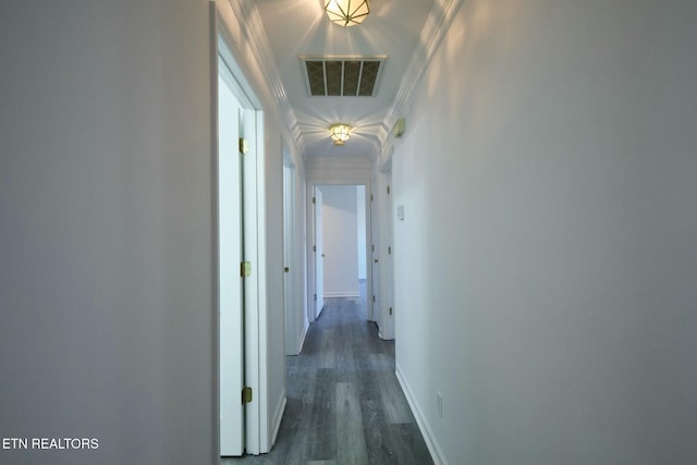 corridor with baseboards, visible vents, dark wood-type flooring, and ornamental molding