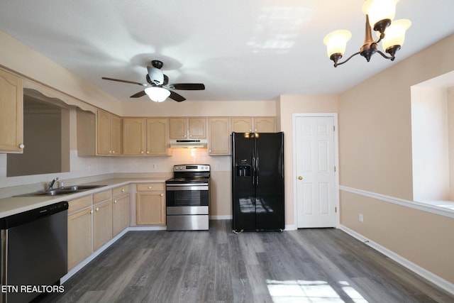 kitchen with appliances with stainless steel finishes, light countertops, a sink, and light brown cabinetry