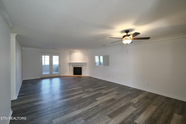 unfurnished living room with dark wood-style floors, plenty of natural light, a fireplace, and ornamental molding