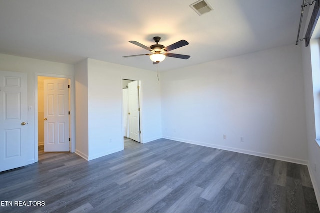 unfurnished bedroom with baseboards, visible vents, dark wood finished floors, and a ceiling fan