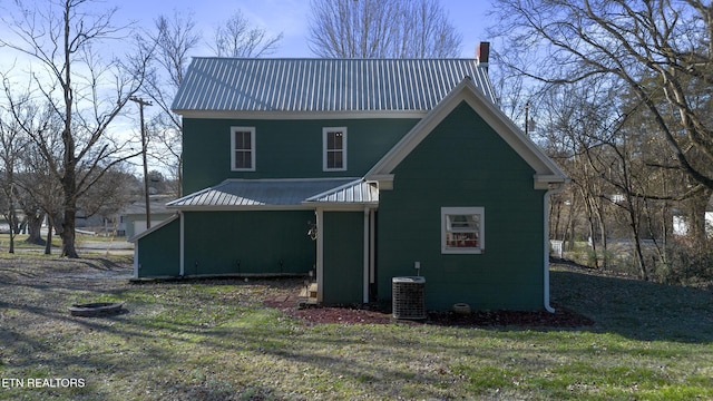 rear view of property featuring a yard and central AC unit