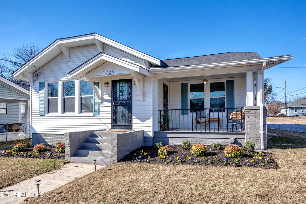 view of front of property with a porch and a front lawn