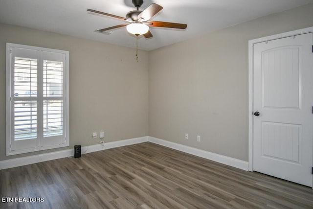 unfurnished room featuring ceiling fan, a healthy amount of sunlight, and dark hardwood / wood-style flooring