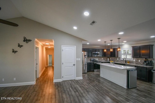 kitchen with appliances with stainless steel finishes, dark hardwood / wood-style floors, sink, hanging light fixtures, and a center island