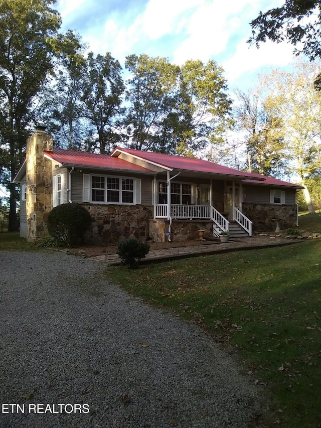 ranch-style home with covered porch and a front yard