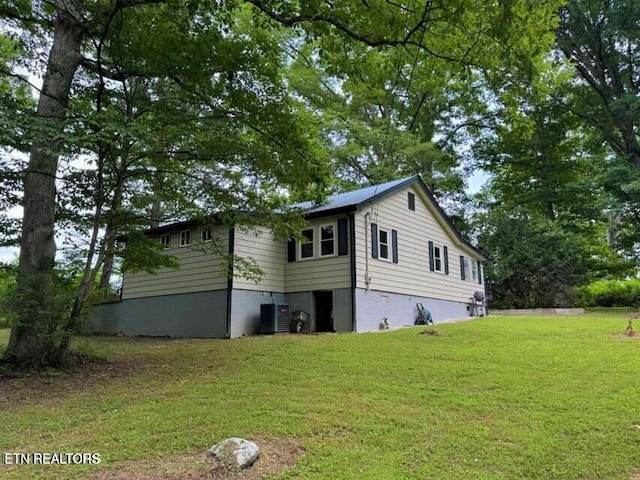 view of home's exterior featuring cooling unit and a yard