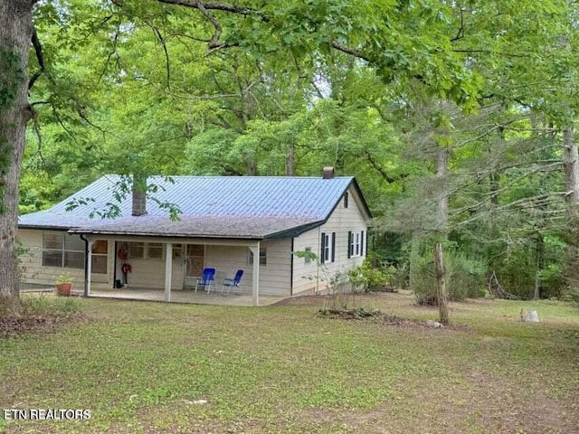 view of front facade with a front lawn and a patio