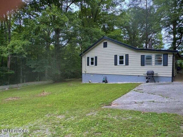 view of side of home with a yard