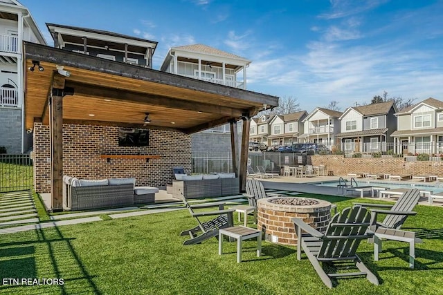 view of yard featuring an outdoor living space with a fire pit, ceiling fan, and a patio area