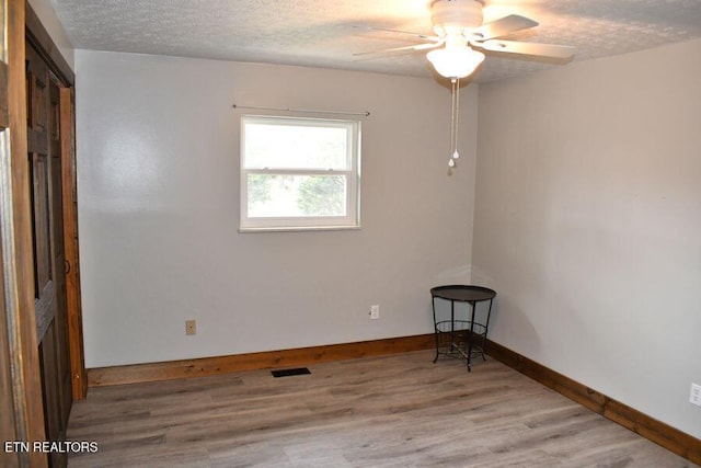 unfurnished room featuring wood-type flooring, ceiling fan, and a textured ceiling