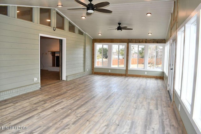 unfurnished sunroom with vaulted ceiling and ceiling fan