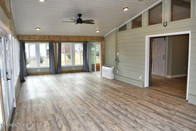 unfurnished sunroom featuring ceiling fan and vaulted ceiling