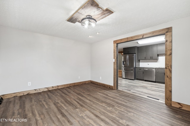 interior space with a textured ceiling and wood-type flooring