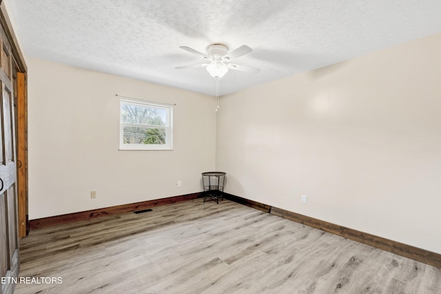 unfurnished room with light wood-type flooring, ceiling fan, and a textured ceiling