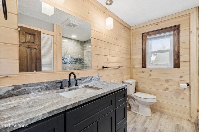 bathroom featuring wooden walls, vanity, toilet, and hardwood / wood-style floors