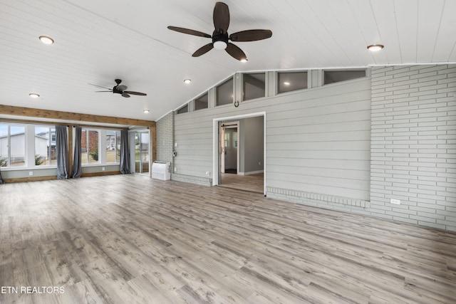 unfurnished living room with lofted ceiling, light wood-type flooring, ceiling fan, wooden ceiling, and brick wall