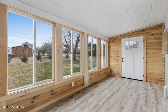 unfurnished sunroom with lofted ceiling, a healthy amount of sunlight, and wood ceiling