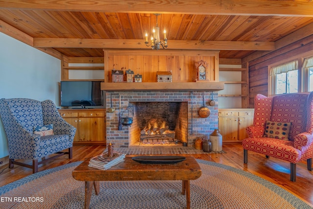 living room featuring beamed ceiling, wood-type flooring, a brick fireplace, and wood ceiling