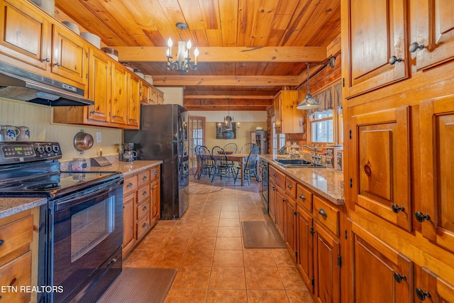 kitchen featuring pendant lighting, light stone counters, an inviting chandelier, and black appliances