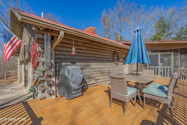 wooden terrace with area for grilling and a sunroom