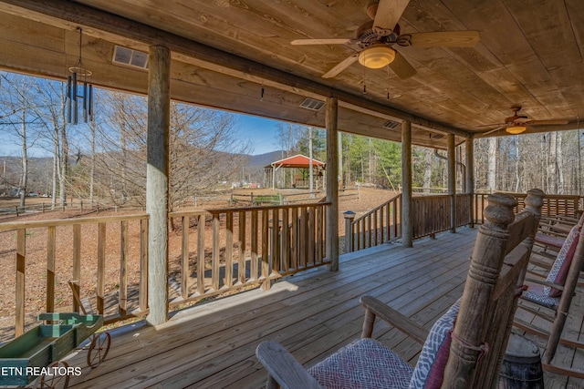 wooden deck with a mountain view and ceiling fan