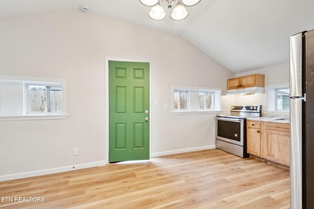 kitchen featuring lofted ceiling, appliances with stainless steel finishes, a chandelier, and light wood-type flooring