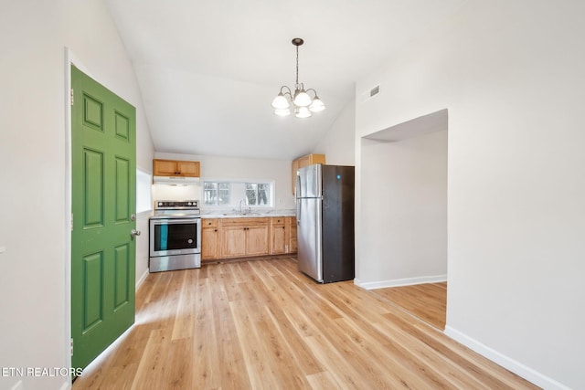 kitchen with sink, stainless steel appliances, light hardwood / wood-style floors, light brown cabinetry, and vaulted ceiling