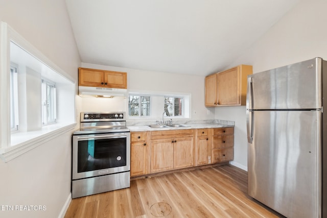 kitchen with stainless steel appliances, lofted ceiling, sink, and light hardwood / wood-style floors