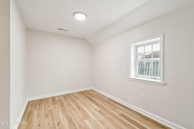 empty room featuring vaulted ceiling and hardwood / wood-style floors