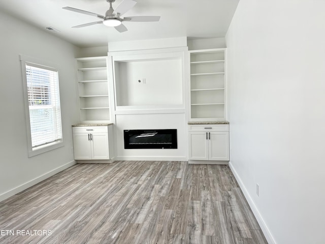 unfurnished living room featuring ceiling fan and light hardwood / wood-style flooring