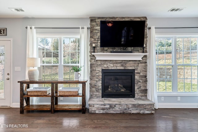 living room with dark hardwood / wood-style flooring, a fireplace, and a healthy amount of sunlight