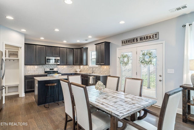 kitchen featuring stainless steel appliances, dark hardwood / wood-style flooring, a center island, and sink